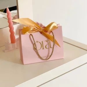 Custom Light Pink Paperboard Bag with Gold Hot Stamping and Detachable Gold Bow