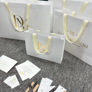 Elegant White Paper Shopping Bag with Custom Gold Foil Logo Sturdy Ribbon Handle Gift Bag for Jewelry Fashion High End Retail